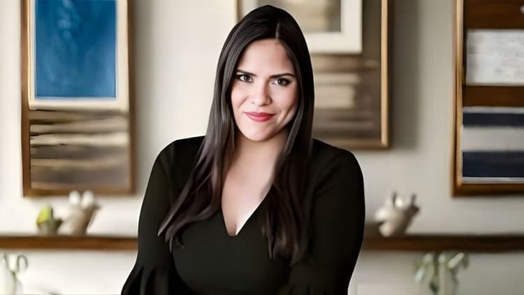 A woman with long dark hair is seated in a calming room, emphasizing the importance of sensory-friendly spaces.