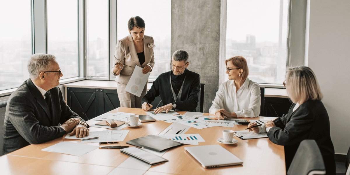 Group of professionals discussing charts and graphs in a modern conference room