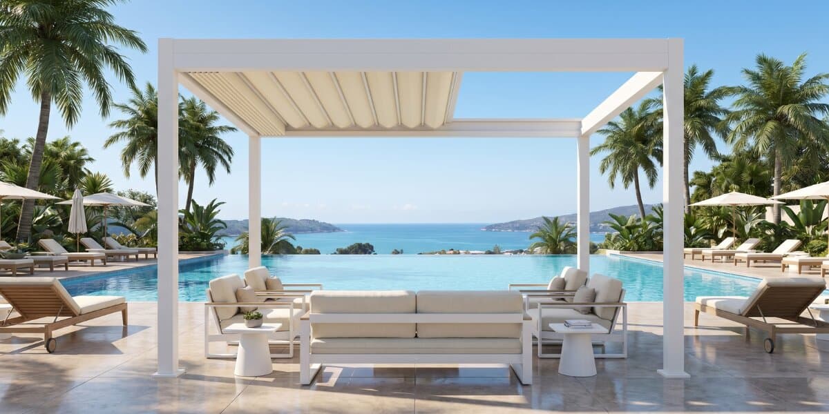 White retractable fabric pergola overlooking an infinity pool with ocean views and outdoor lounge seating.