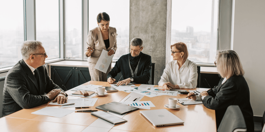 Group of professionals discussing charts and graphs in a modern conference room