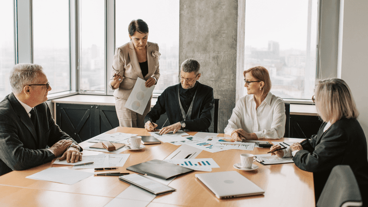 Group of professionals discussing charts and graphs in a modern conference room
