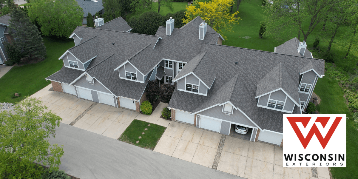 Aerial view of two residential buildings with garages and green landscaping