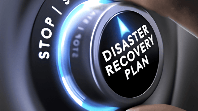 A hand adjusting a dial labeled "DISASTER RECOVERY PLAN" on a control panel