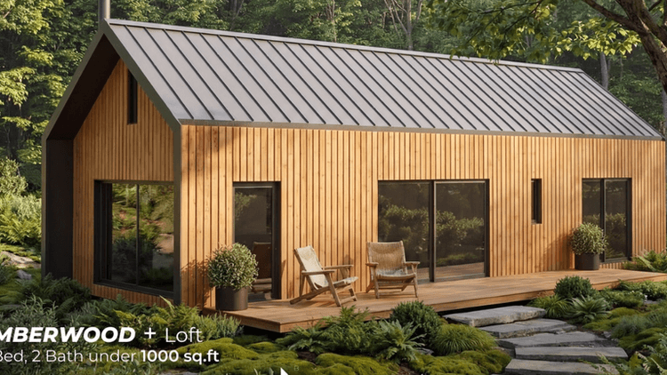 Modern wood cabin with loft, black metal roof, and large windows surrounded by lush forest landscaping.