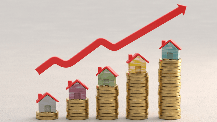 Colorful model houses on stacks of coins beneath an upward arrow representing rising housing market growth.